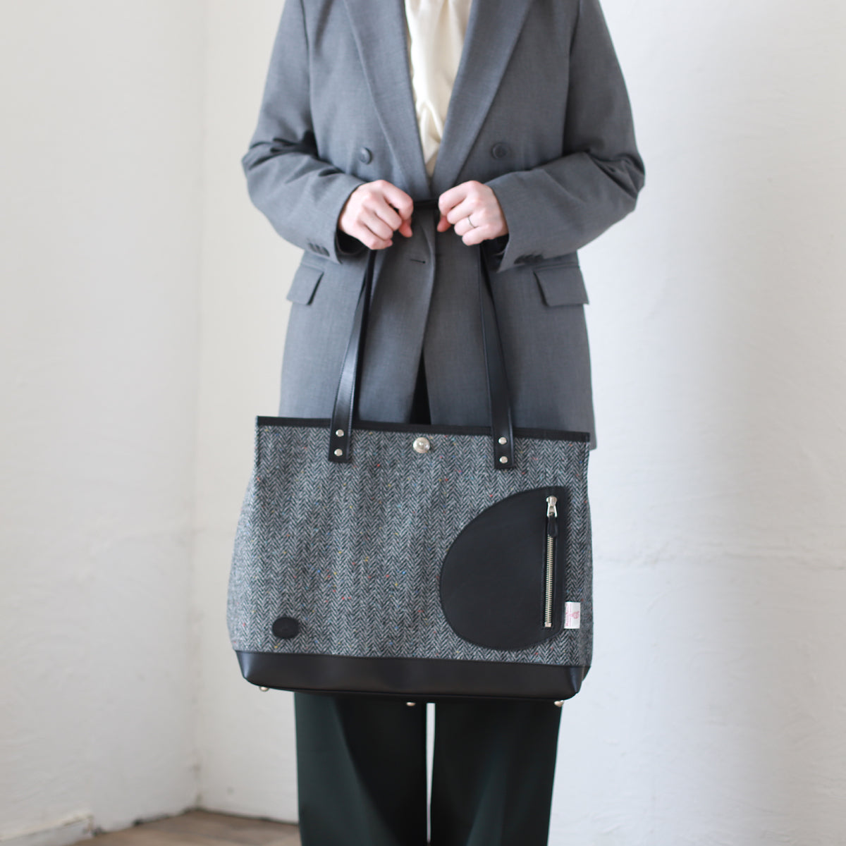 トートバッグ ｜ ハリスツイード 防水牛革 多収納 着用イメージ 女性 オフィスカジュアル 手提げ 正面