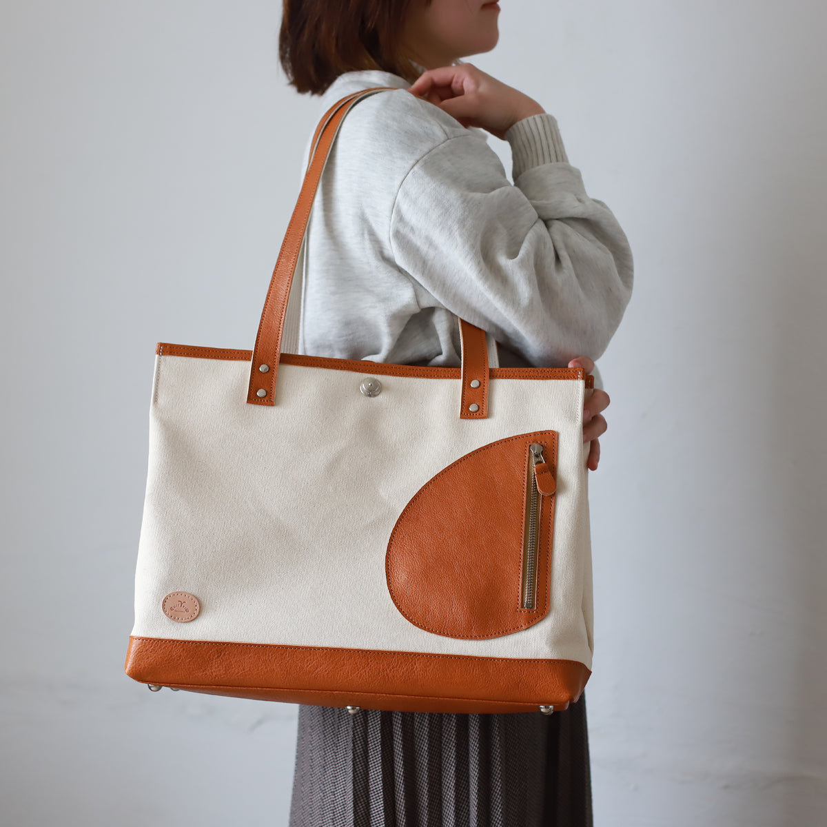 トートバッグ DUOトートver2 ｜ 帆布 牛革 キャメル×オフホワイト 使用イメージ 女性 側面