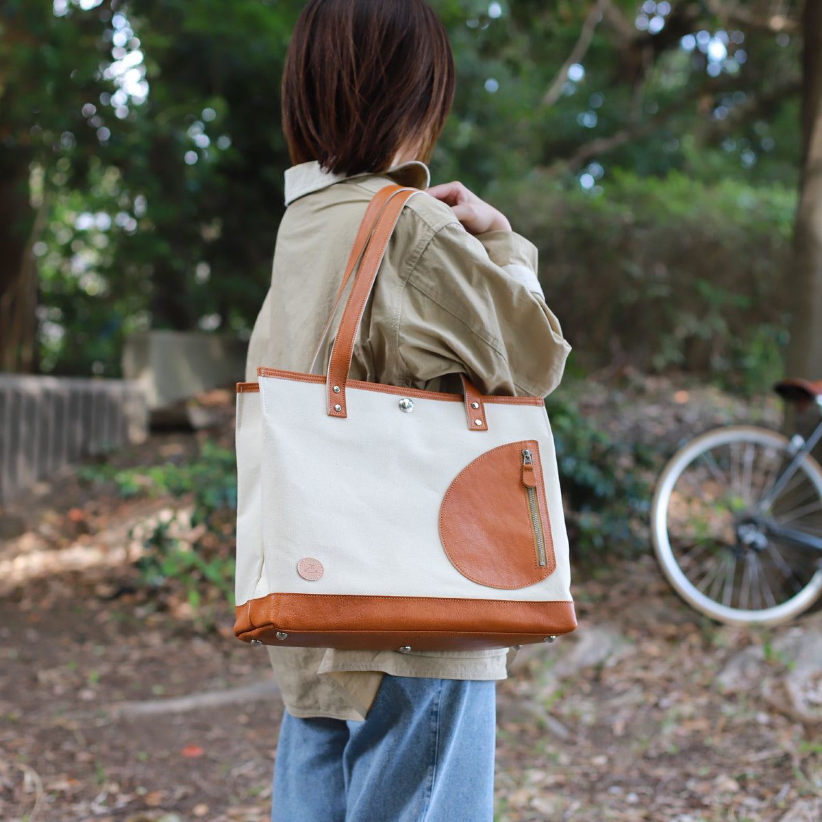 トートバッグ DUOトートver2 ｜ 帆布 牛革 キャメル×オフホワイト 使用イメージ 女性 公園