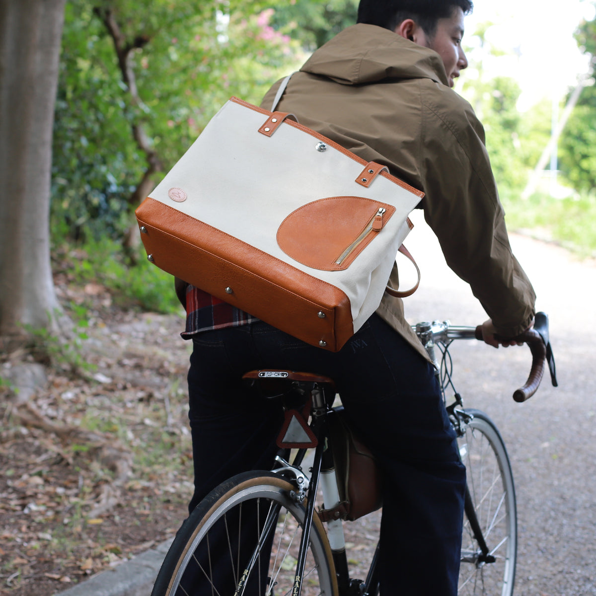 トートバッグ DUOトートver2 ｜ 帆布 牛革 キャメル×オフホワイト 使用イメージ 男性 自転車 公園